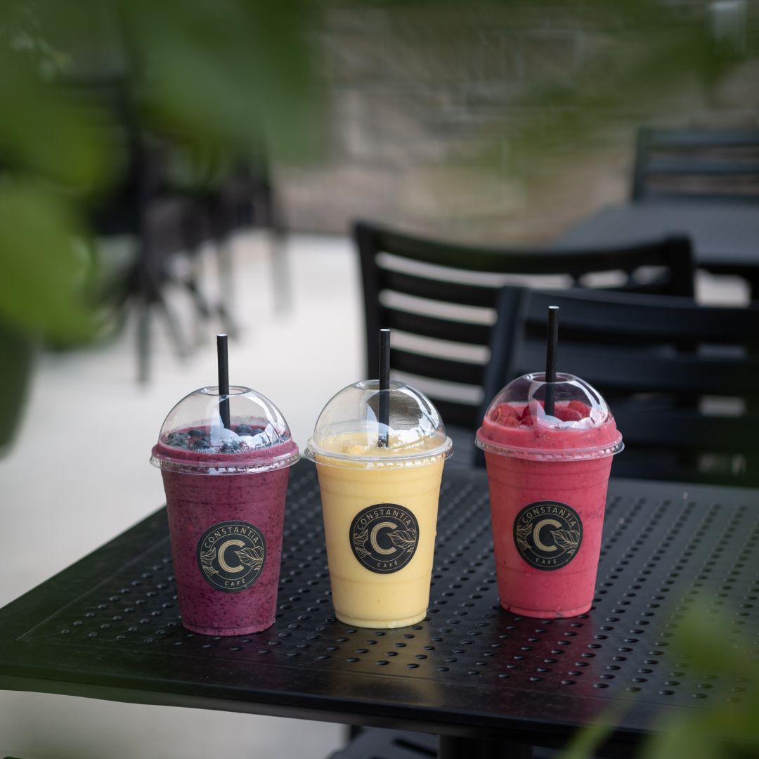 Trois smoothies colorés Café Constantia sur table de terrasse